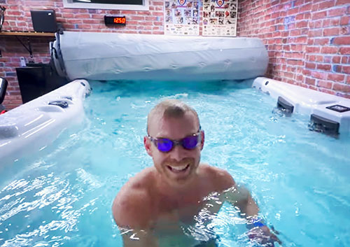 Taren Gesell swimming in his h2x swim spa