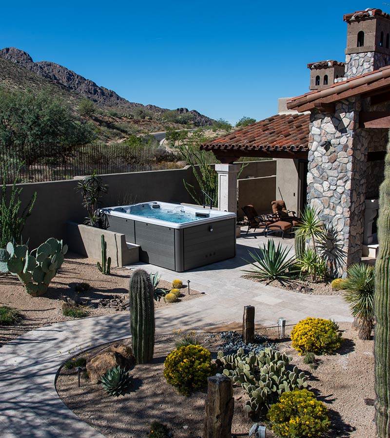 A concrete privacy fence and plants create a sense of privacy for ultimate swim spa enjoyment