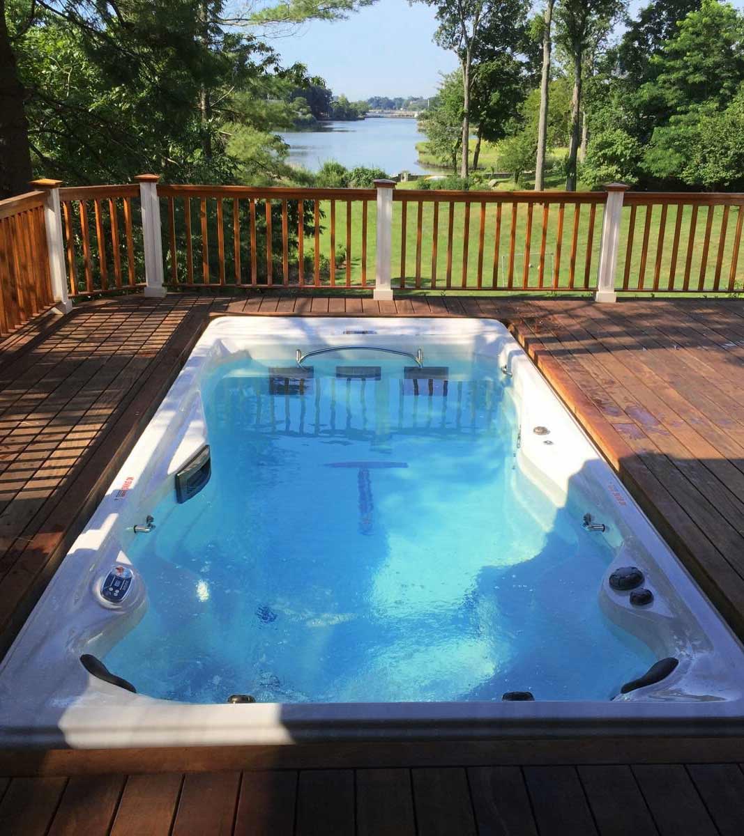 Recessed swim spa installation in a deck with a view of the water