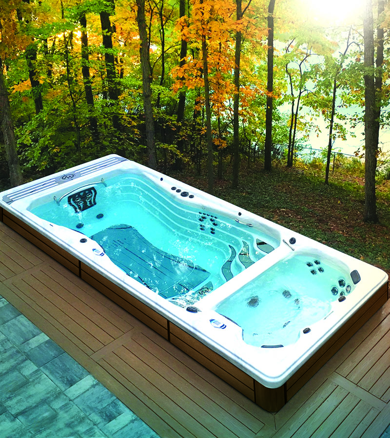 A canopy of trees provide shade and privacy for this swim spa, which is installed in a deck