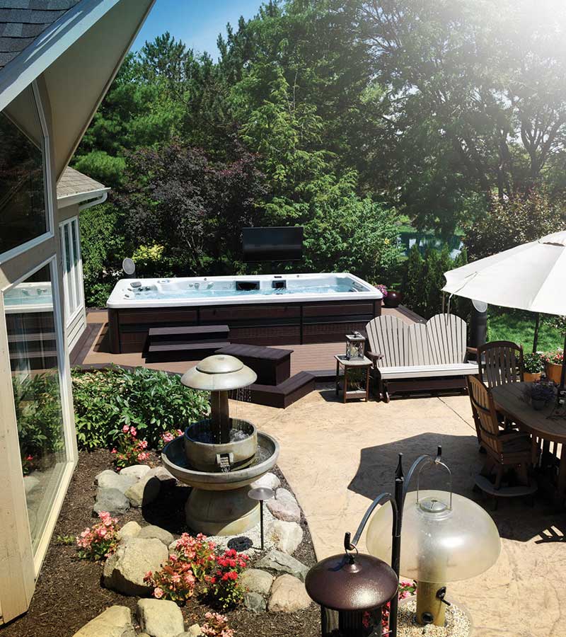 Create an outdoor living space with ample seating, fountain, and lush landscaping