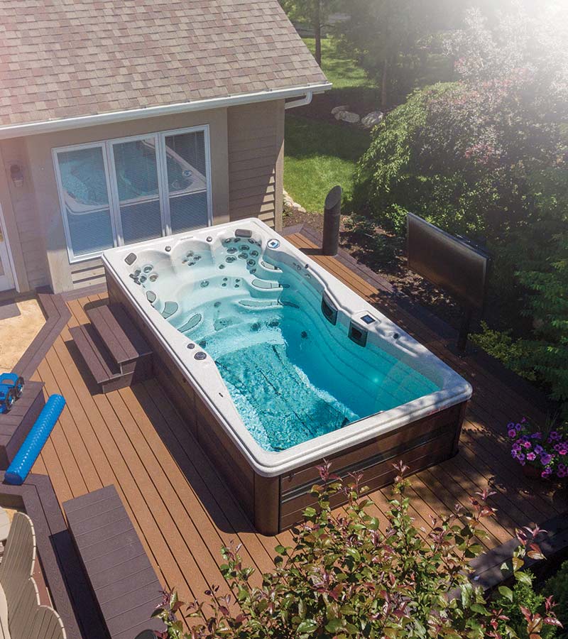 This swim spa installation features a custom deck and outdoor entertainment system