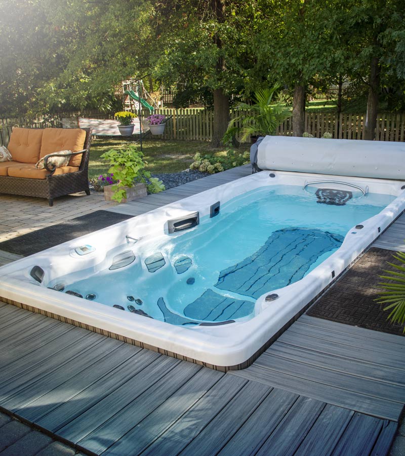 This recessed swim spa installation is surrounded by decking and patio pavers