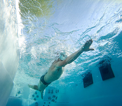 underwater shot of ben hoffman swimming in an h2x fitness swim spa