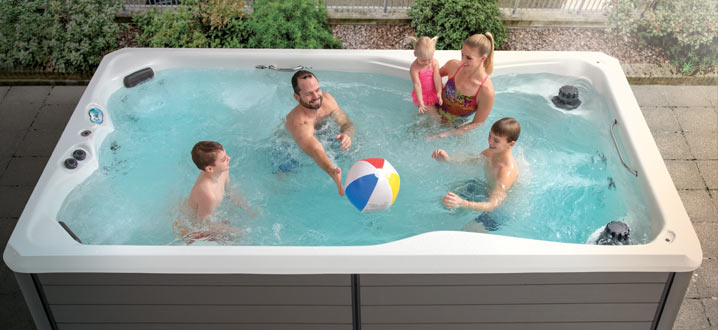 Family playing with a beach ball in a swim spa