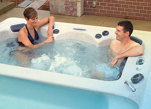 Couple relaxing watching a movie on their ipad in the h2x swimspa