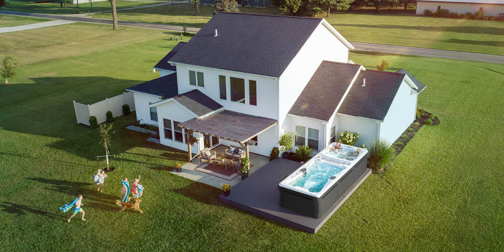 Drone view of a home's backyard that includes a swim spa.